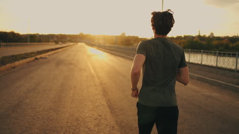 male-athlete-is-running-on-road-in-sunrise-or-sunset-sportsman-is-training-outdoors-preparing-to-marathon